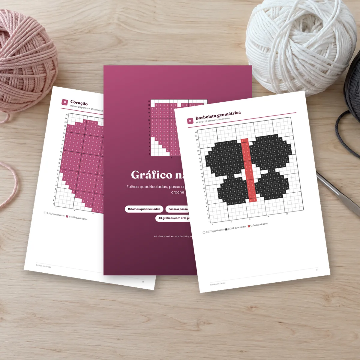 Folhas do Gráfico na Grade sobre a mesa, com novelos de linha. Montagem com páginas reais do PDF.
